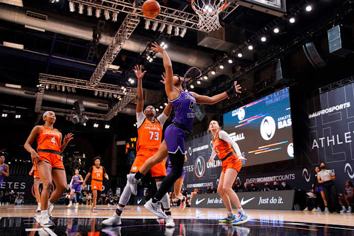 Team Carrington guard/forward DiJonai Carrington goes up for a layup with defenders around her